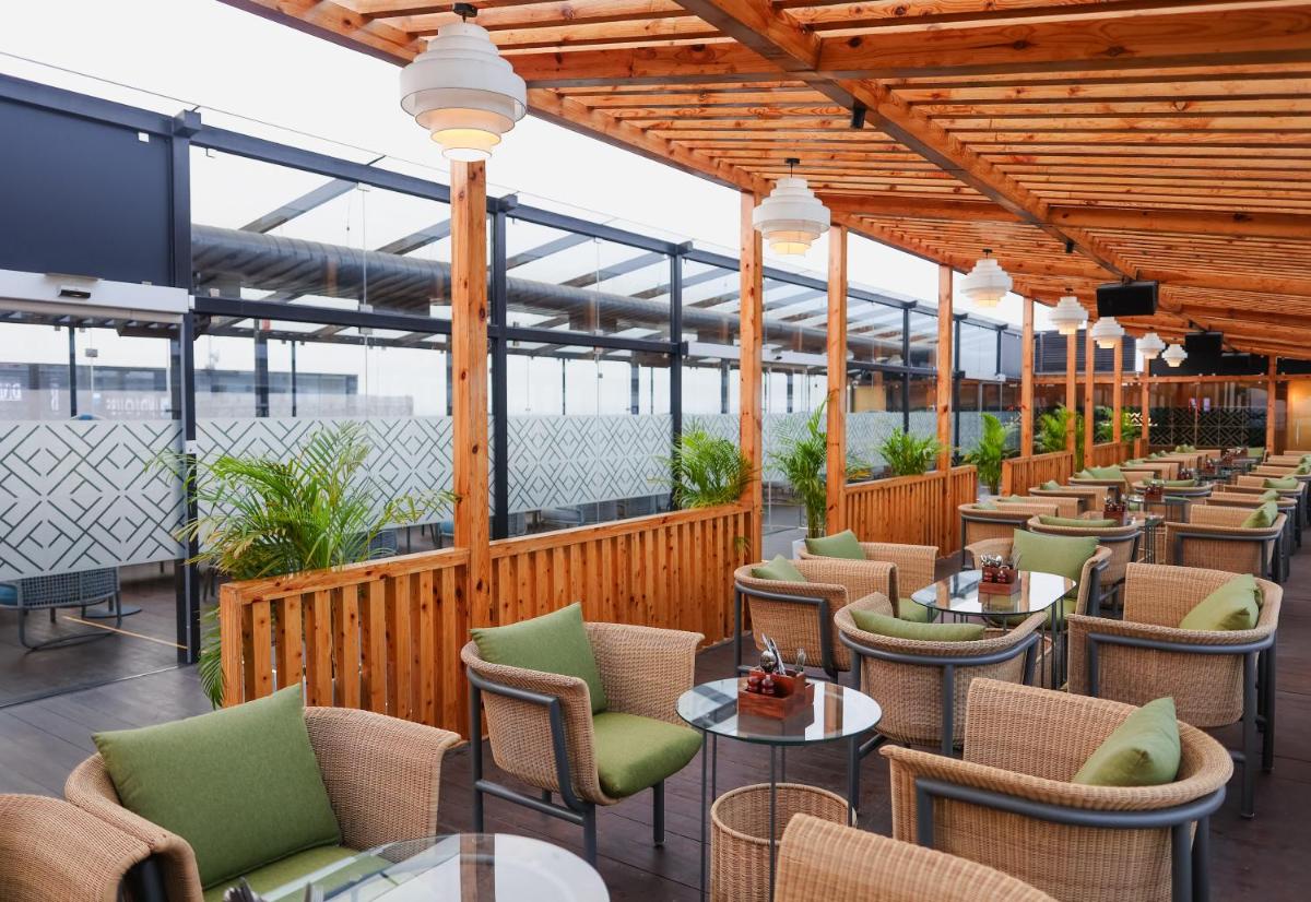 a restaurant with tables and chairs on a deck at Hilton Chennai in Chennai