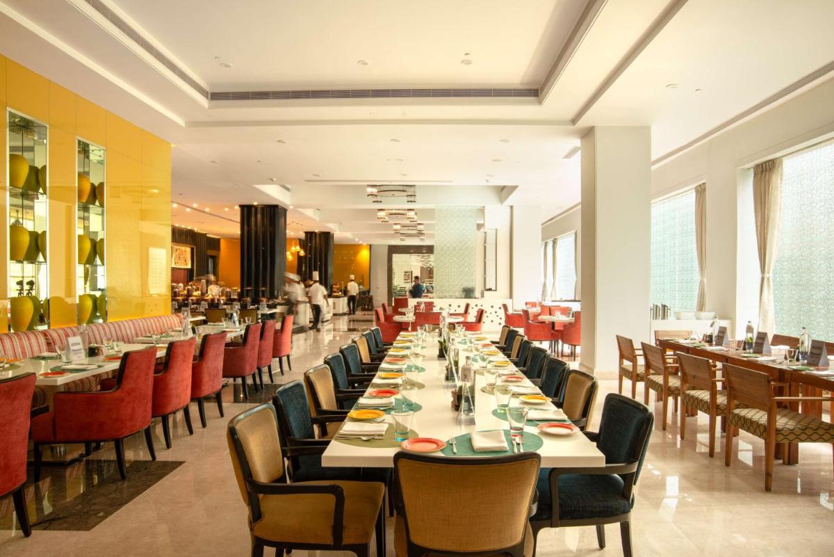 a large dining room with tables and chairs at Radisson Blu Bengaluru Outer Ring Road in Bengaluru