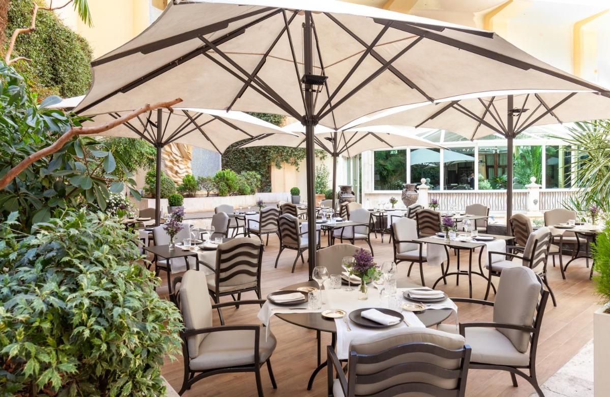 Un restaurante con mesas, sillas y sombrillas. en InterContinental Madrid by IHG, en Madrid