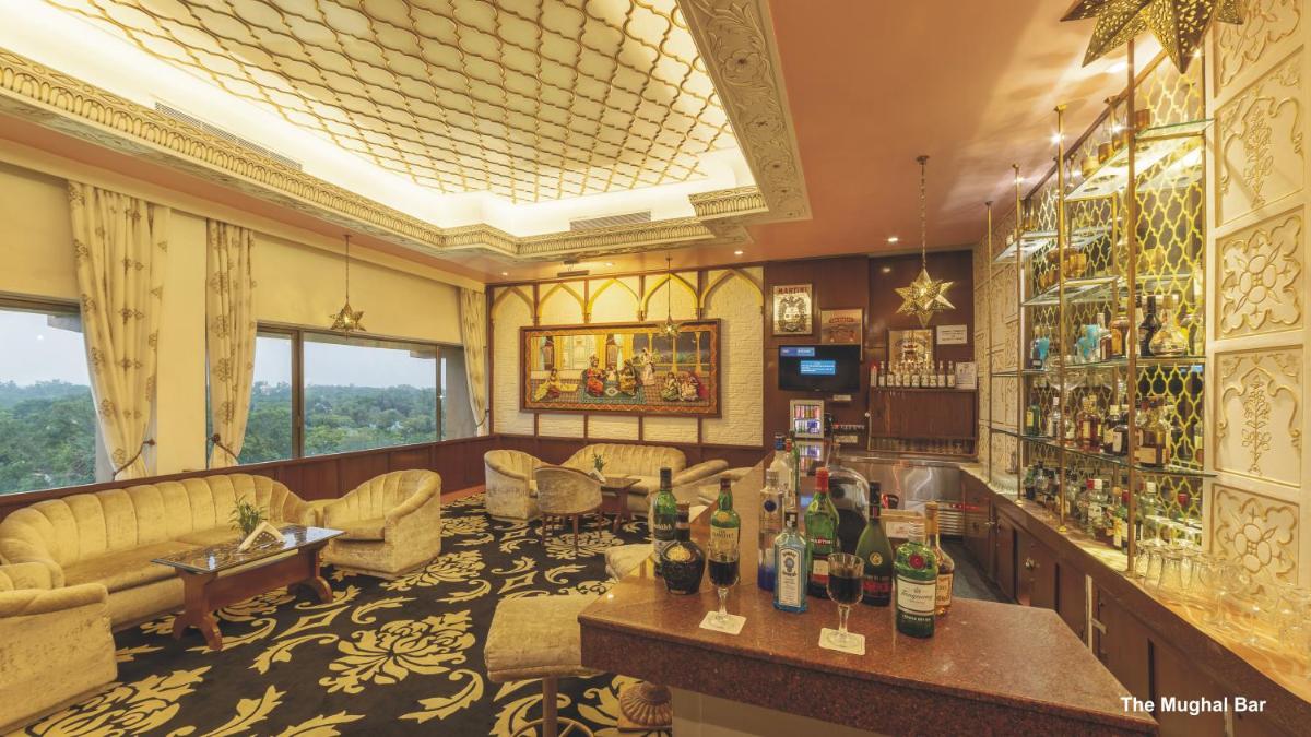 a bar in a room with a lot of furniture at Hotel Clarks Shiraz in Agra