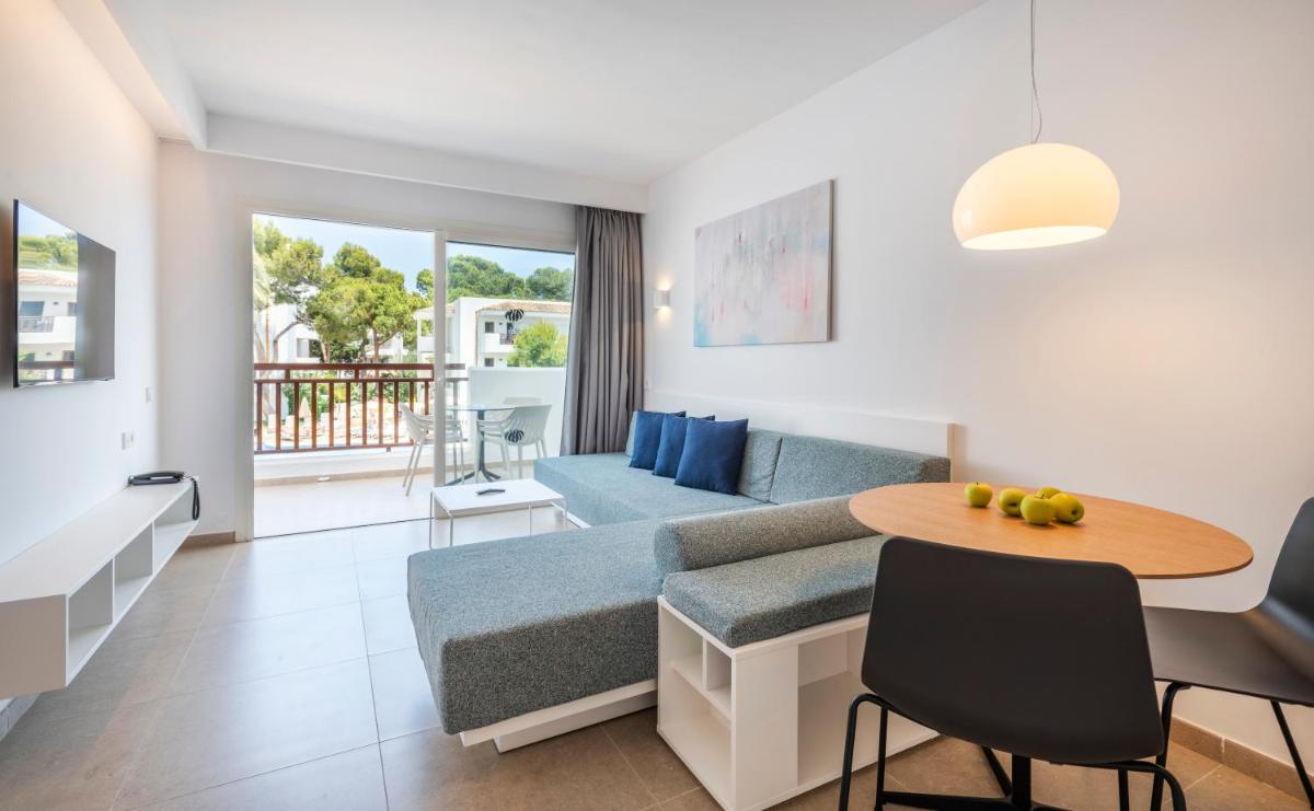 una sala de estar con un sofá y una mesa en Inturotel Cala Azul, en Cala d´Or