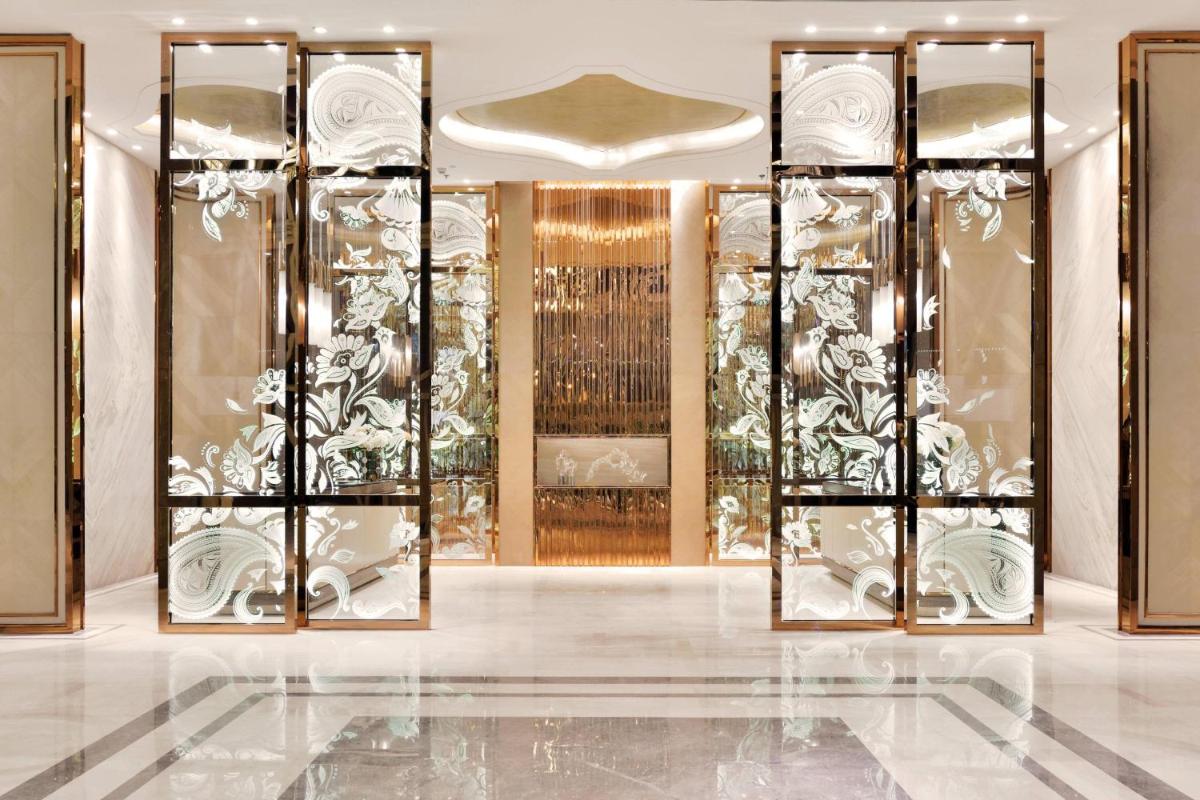 a lobby with gold and white furniture and glass doors at JW Marriott Hotel Kolkata in Kolkata