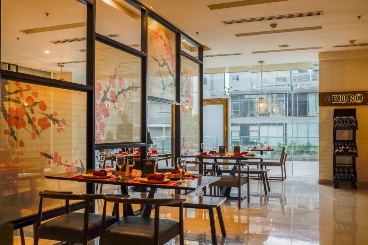 a row of tables and chairs in a restaurant at Renaissance Ahmedabad Hotel in Ahmedabad +81 photos