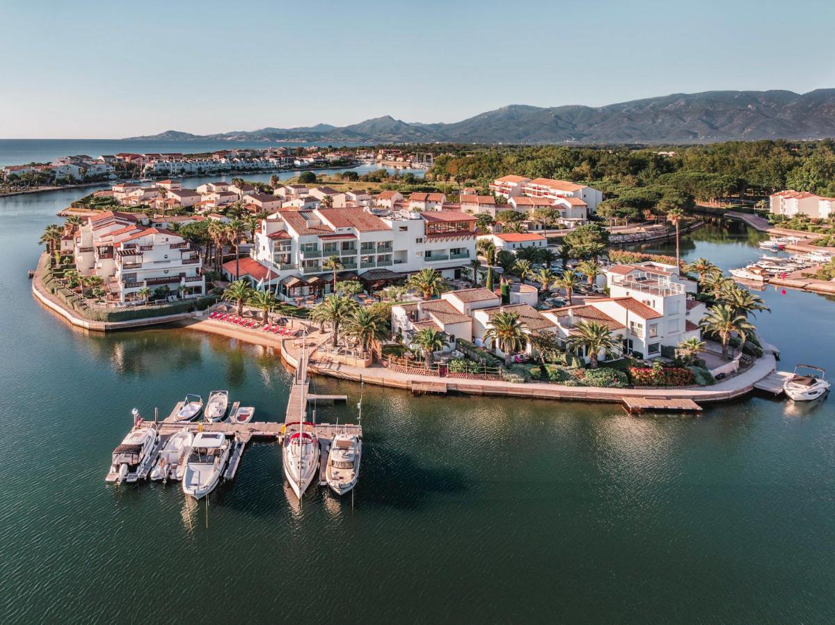 une vue aérienne d'une station balnéaire avec des bateaux dans l'eau dans l'établissement Relais et Châteaux Thalasso & Spa Ile de la Lagune, à Saint-Cyprien