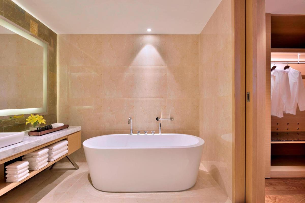 a bathroom with a tub and a sink at Marriott Executive Apartments Hyderabad in Hyderabad