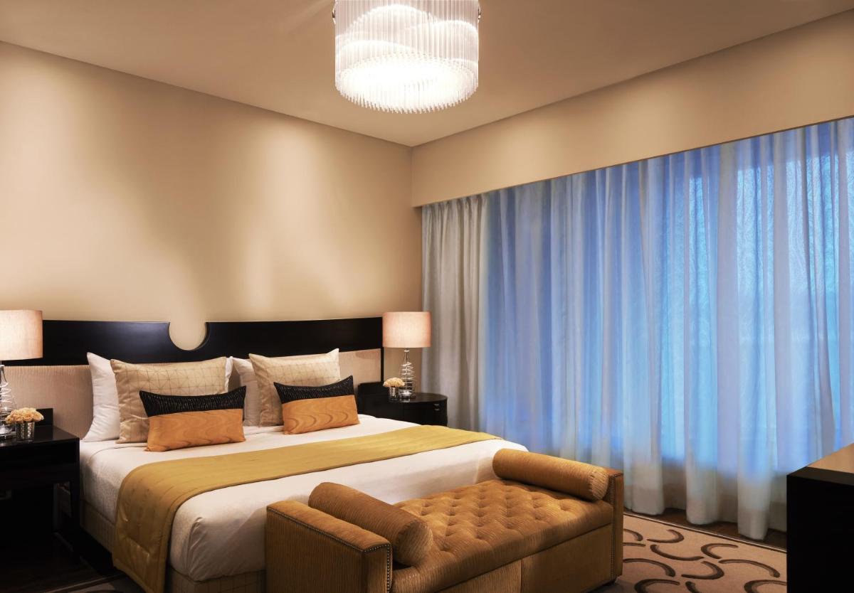 a bedroom with a large bed and a large window at Taj Santacruz in Mumbai