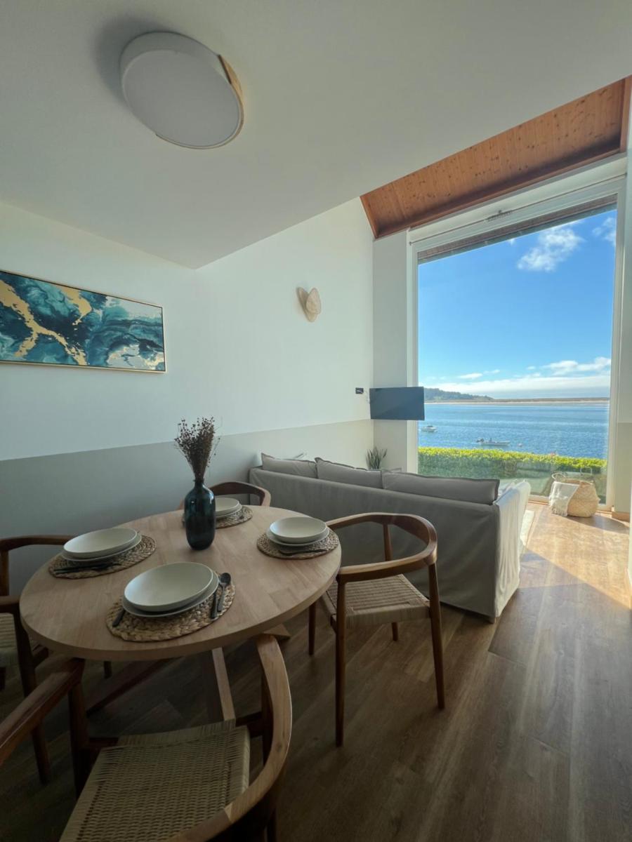 - Sala de estar con mesa y sillas y vistas al océano en Porto Cabana by Miramar Stays, en Cabana de Bergantiños