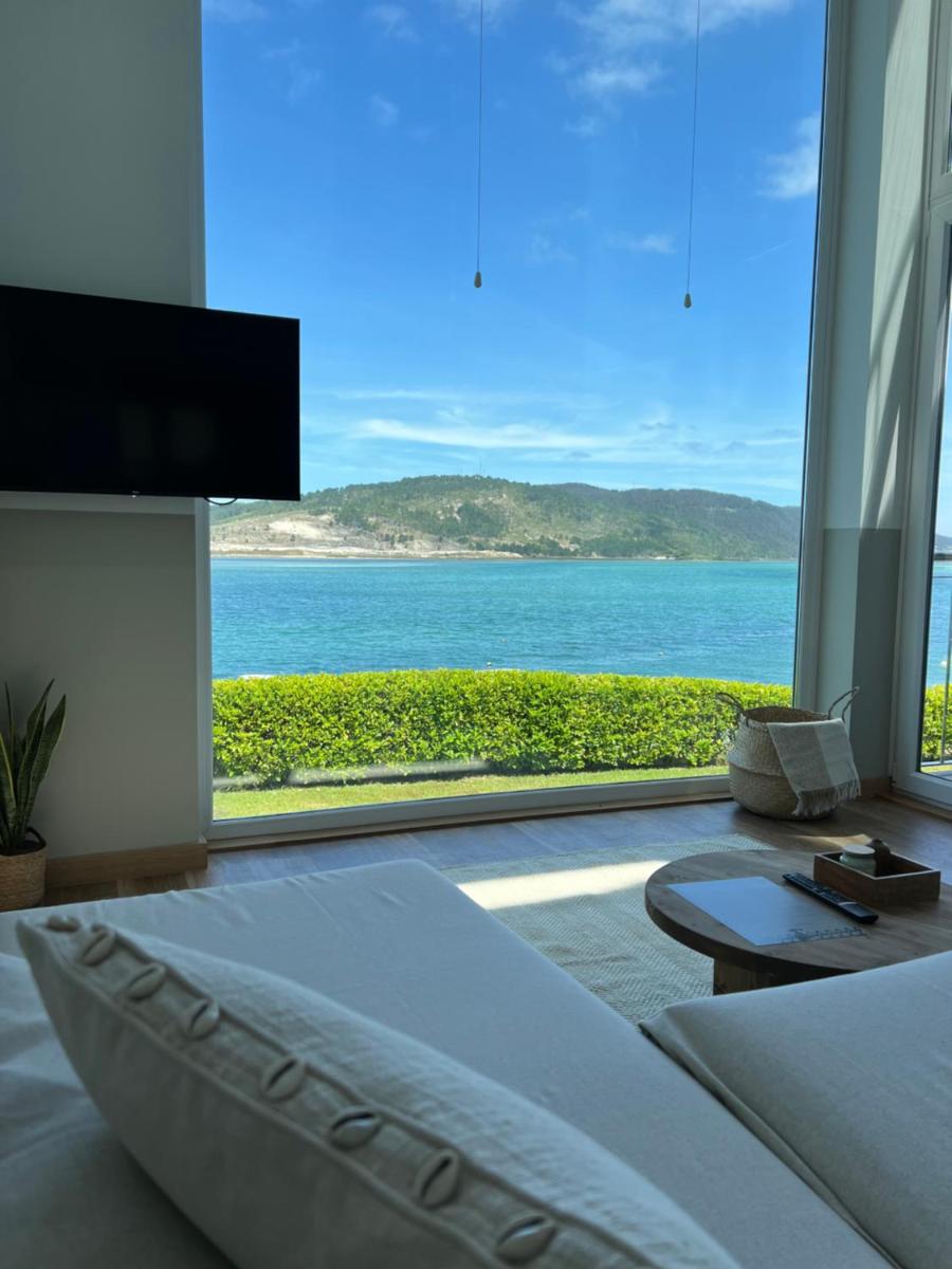 Un dormitorio con una cama y vista al mar. en Porto Cabana by Miramar Stays, en Cabana de Bergantiños