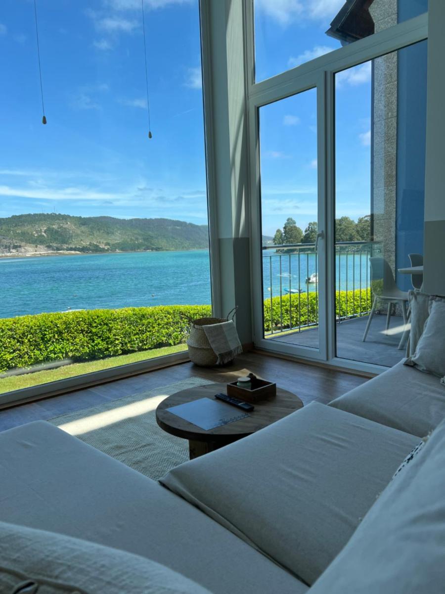 Una sala de estar con vista al mar. en Porto Cabana by Miramar Stays, en Cabana de Bergantiños