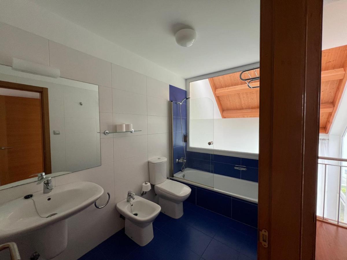Un baño con lavabo, inodoro y espejo. en Porto Cabana by Miramar Stays, en Cabana de Bergantiños 48 fotos más