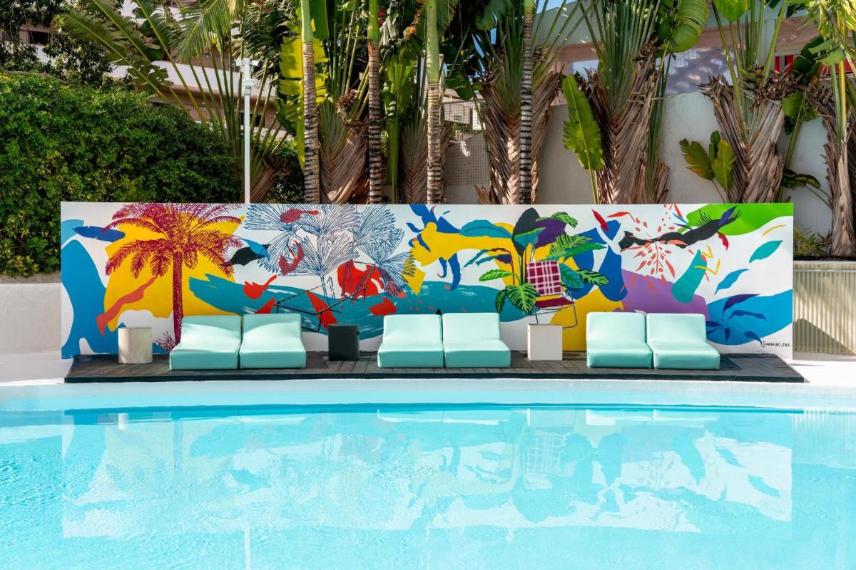 una piscina en un complejo con una pared colorida en Gold By Marina - Adults only, en Playa del Inglés