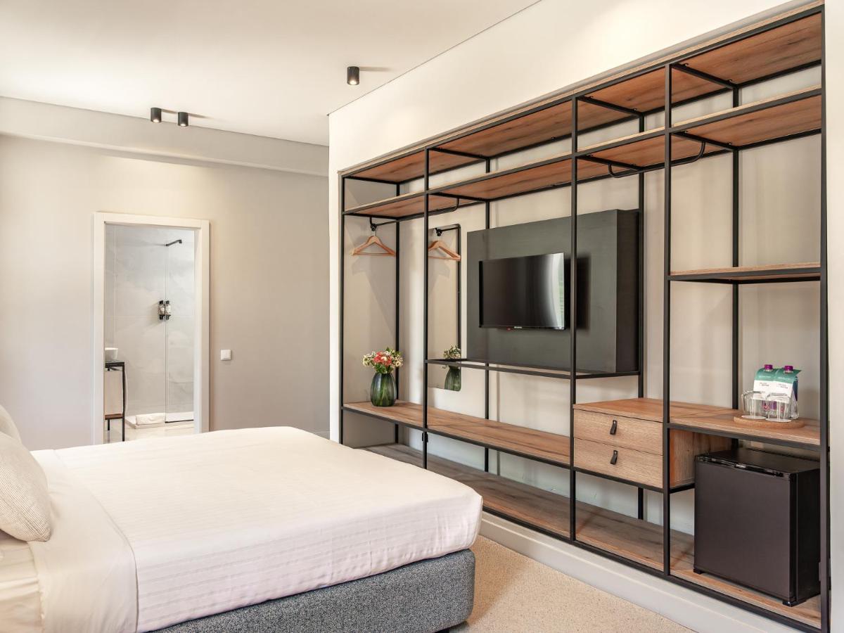 um quarto com uma grande cama branca e uma televisão de ecrã plano em Villa Termal Spa Hotel - Villa Termal Spa Resort - by Unlock Hotels em Monchique