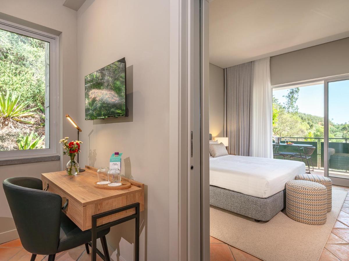 um quarto de hotel com uma cama e uma secretária e um quarto em Villa Termal Spa Hotel - Villa Termal Spa Resort - by Unlock Hotels em Monchique mais 50 fotografias