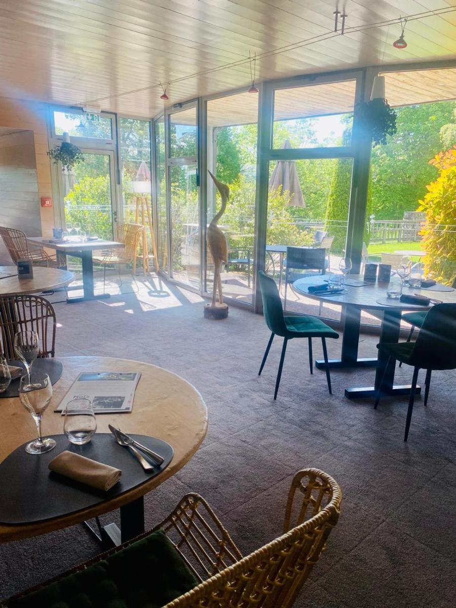 un restaurant avec des tables et des chaises et une girafe en arrière-plan dans l'établissement Hob Fort du Pré, à Saint-Bonnet-le-Froid