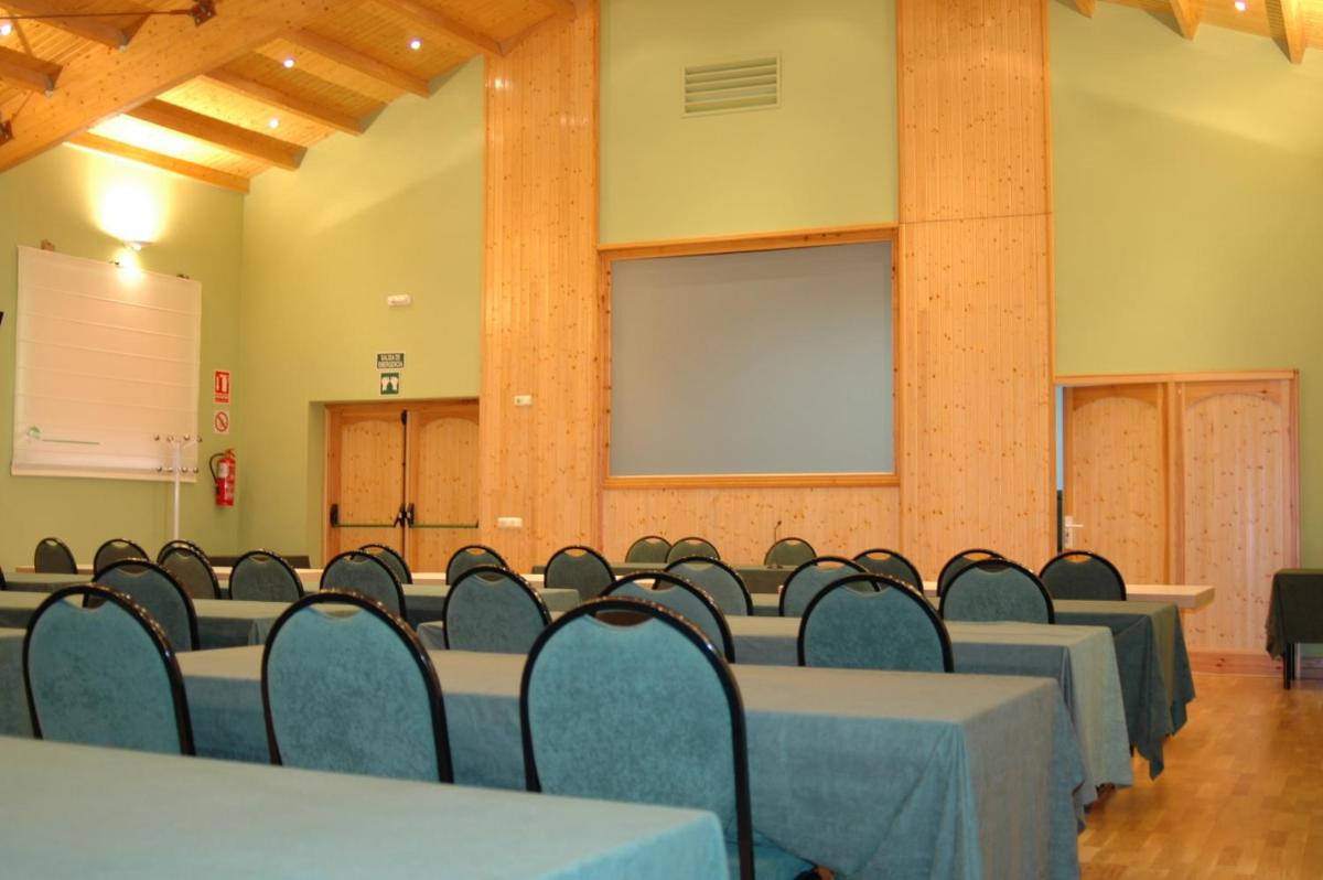 Una sala de conferencias con mesas, sillas y una pantalla. en Balneario Cervantes, en Santa Cruz de Mudela 60 fotos más