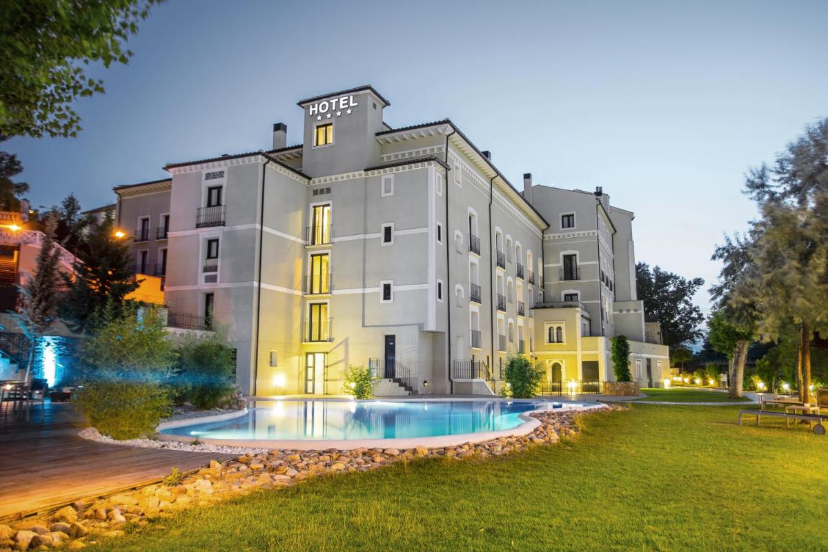 Un gran edificio con una piscina en frente. en Hotel Balneario Alhama de Aragón, en Alhama de Aragón