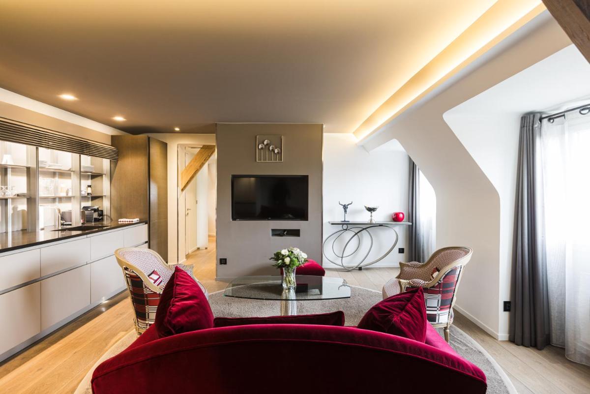 un salon avec des chaises rouges et une table dans l'établissement Plaza Madeleine & Spa, à Sarlat-la-Canéda