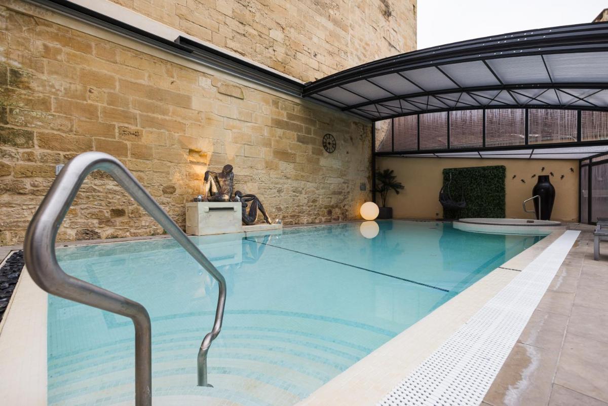 - une grande piscine dans un bâtiment en briques dans l'établissement Plaza Madeleine & Spa, à Sarlat-la-Canéda