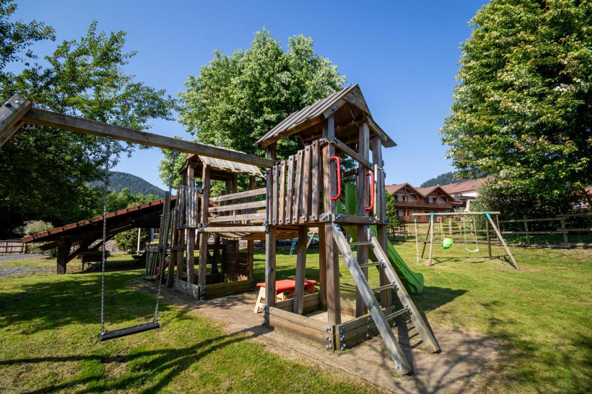 une aire de jeux avec un toboggan et une structure de jeu dans l'établissement Logis Hôtel Le Régal & Spa, à Saint-Dié-des-Vosges