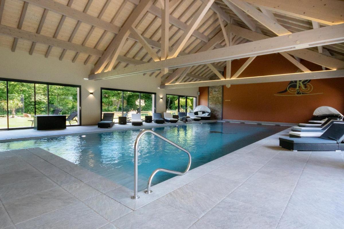 - une grande piscine dans une grande pièce dotée de fenêtres dans l'établissement Logis Hôtel Le Régal & Spa, à Saint-Dié-des-Vosges