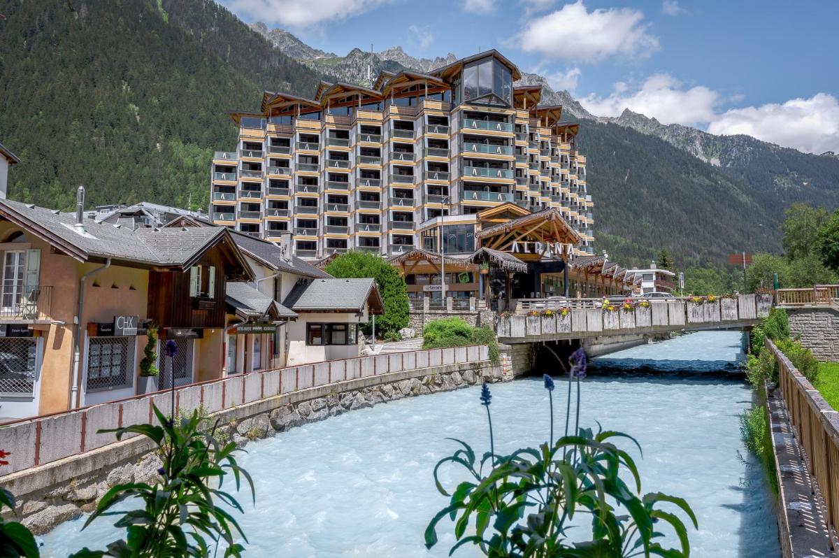 un hôtel avec un pont sur une rivière et des bâtiments dans l'établissement Alpina Eclectic Hotel, à Chamonix-Mont-Blanc
