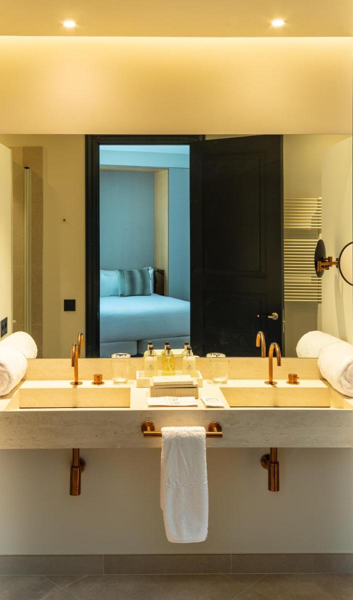 Un baño con dos lavabos y un espejo grande. en Hotel Boutique Sidonia, en Jerez de la Frontera