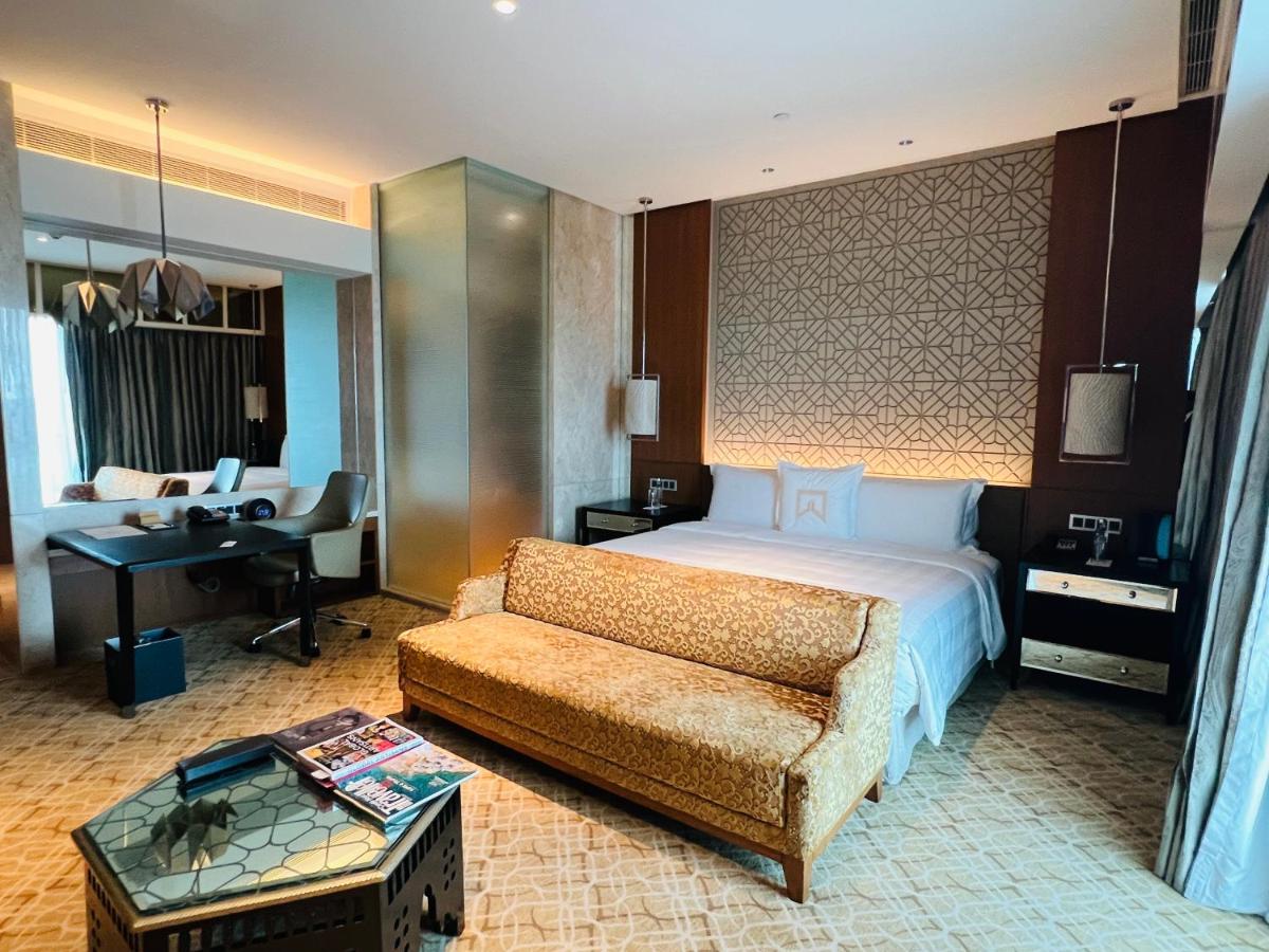 a bedroom with a bed and a couch and a desk at ITC Kohenur, a Luxury Collection Hotel, Hyderabad in Hyderabad