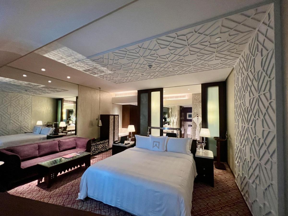 a hotel room with a large bed and a couch at ITC Kohenur, a Luxury Collection Hotel, Hyderabad in Hyderabad