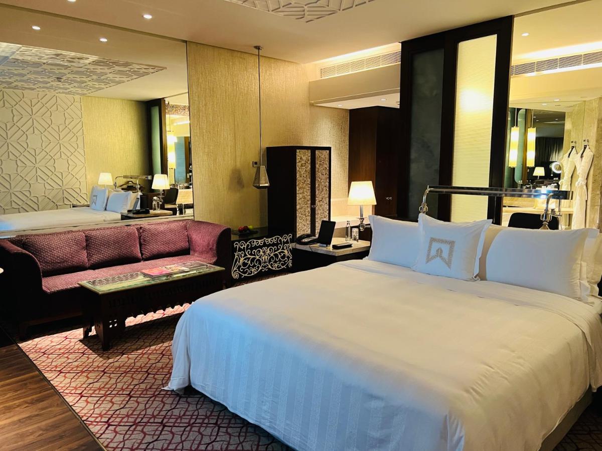 a hotel room with a large bed and a couch at ITC Kohenur, a Luxury Collection Hotel, Hyderabad in Hyderabad