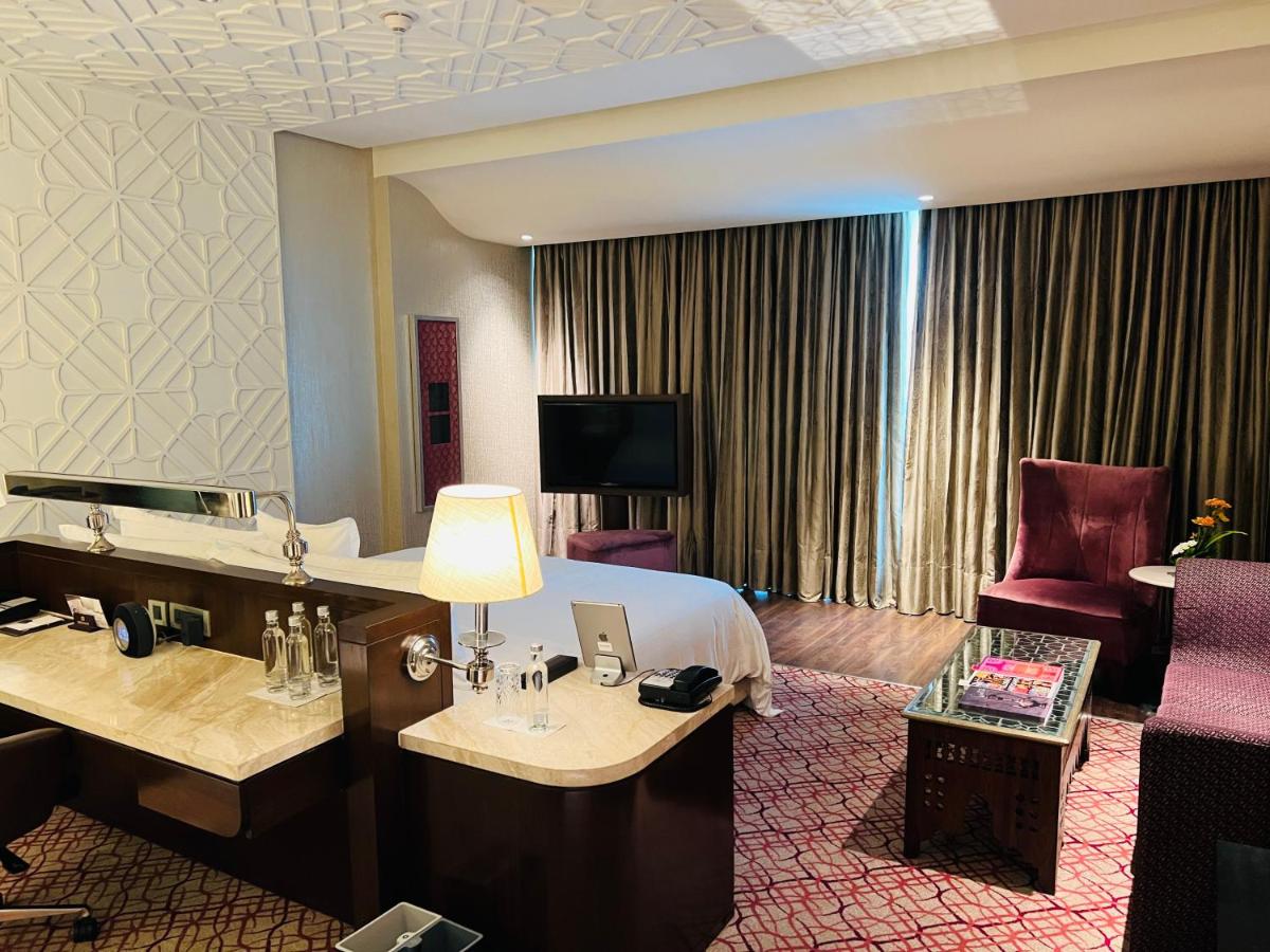 a hotel room with a bed and a living room at ITC Kohenur, a Luxury Collection Hotel, Hyderabad in Hyderabad