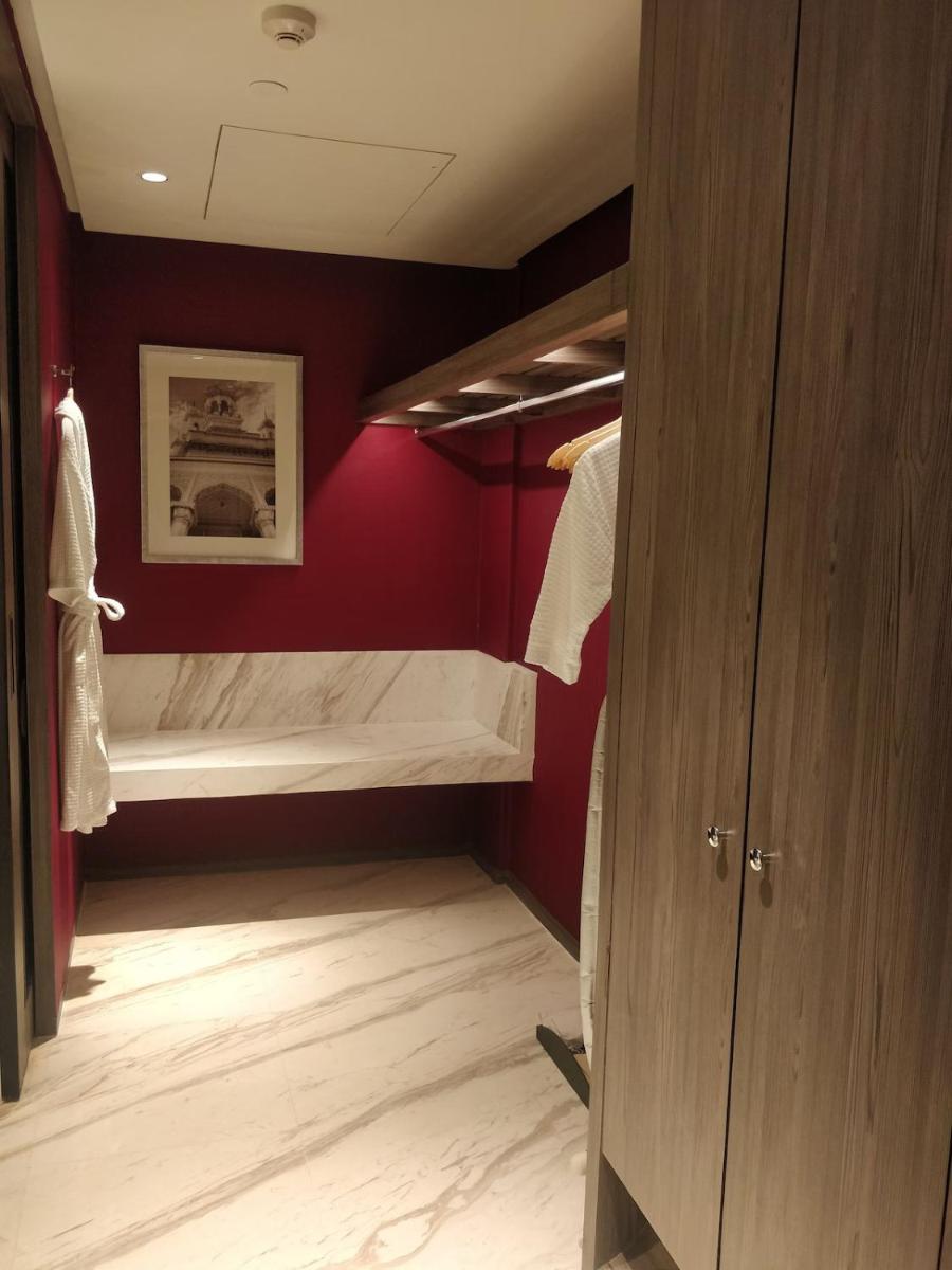 a bedroom with a bed in a red wall at ITC Kohenur, a Luxury Collection Hotel, Hyderabad in Hyderabad