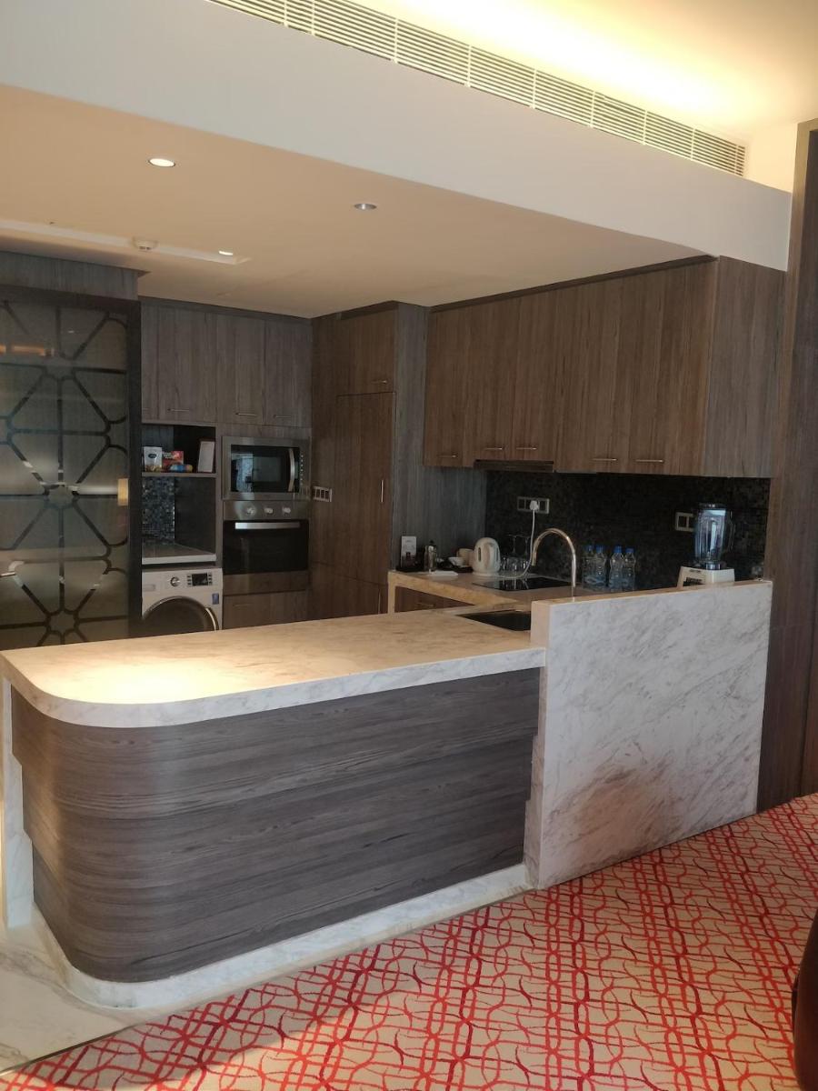 a kitchen with wooden cabinets and a counter top at ITC Kohenur, a Luxury Collection Hotel, Hyderabad in Hyderabad