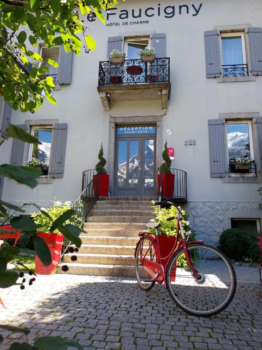 un vélo rouge garé devant un bâtiment dans l'établissement Le Faucigny - Hotel de Charme & SPA, à Chamonix-Mont-Blanc