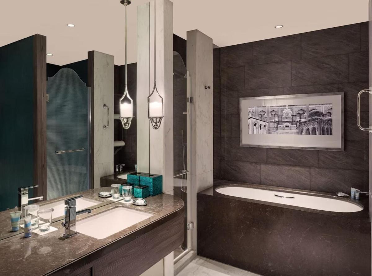 a bathroom with a bath tub and a sink and a bath tub at ITC Kohenur, a Luxury Collection Hotel, Hyderabad in Hyderabad