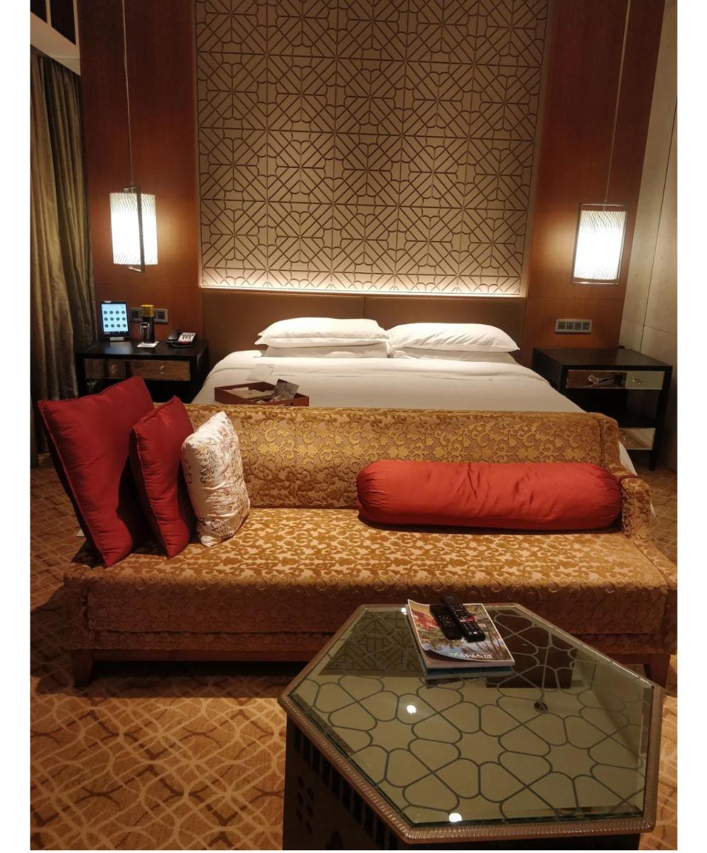 a bedroom with a bed with red pillows and a table at ITC Kohenur, a Luxury Collection Hotel, Hyderabad in Hyderabad