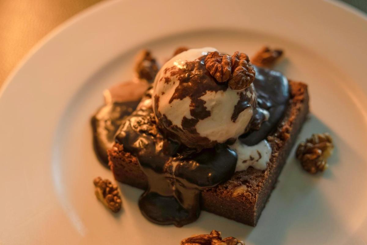 a piece of cake with ice cream and walnuts on a plate at Hyatt Place Pune Hinjawadi in Pune