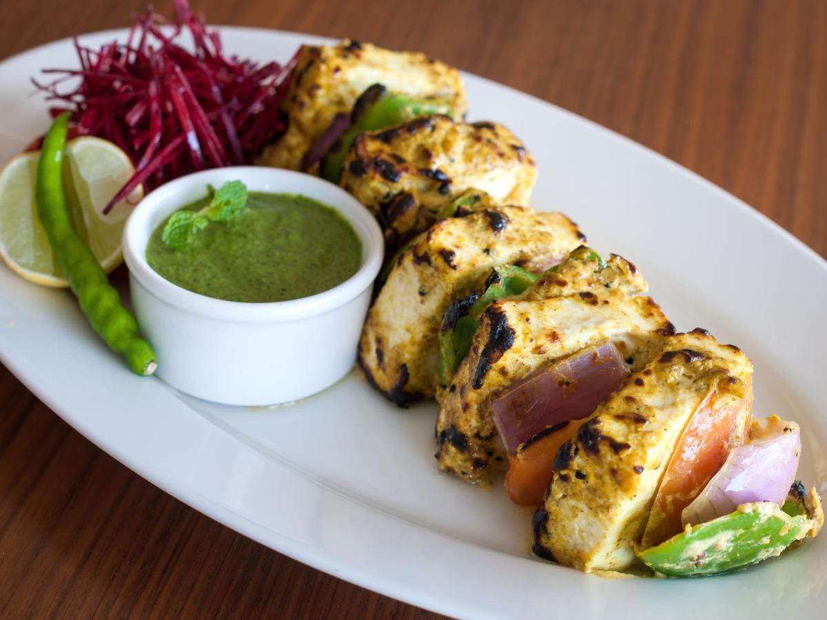 a plate of food with a bowl of green dipping sauce at Hyatt Place Pune Hinjawadi in Pune
