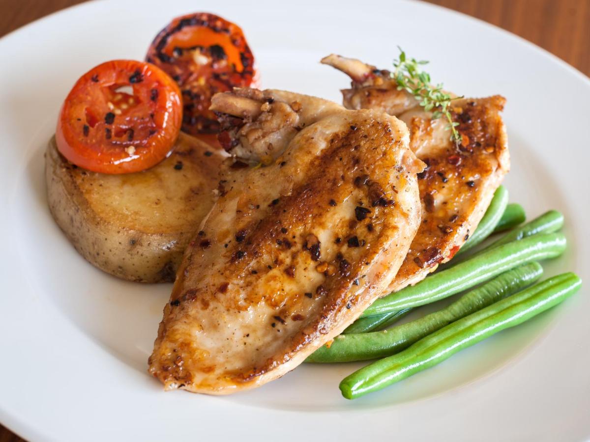 a white plate of food with chicken and vegetables at Hyatt Place Pune Hinjawadi in Pune
