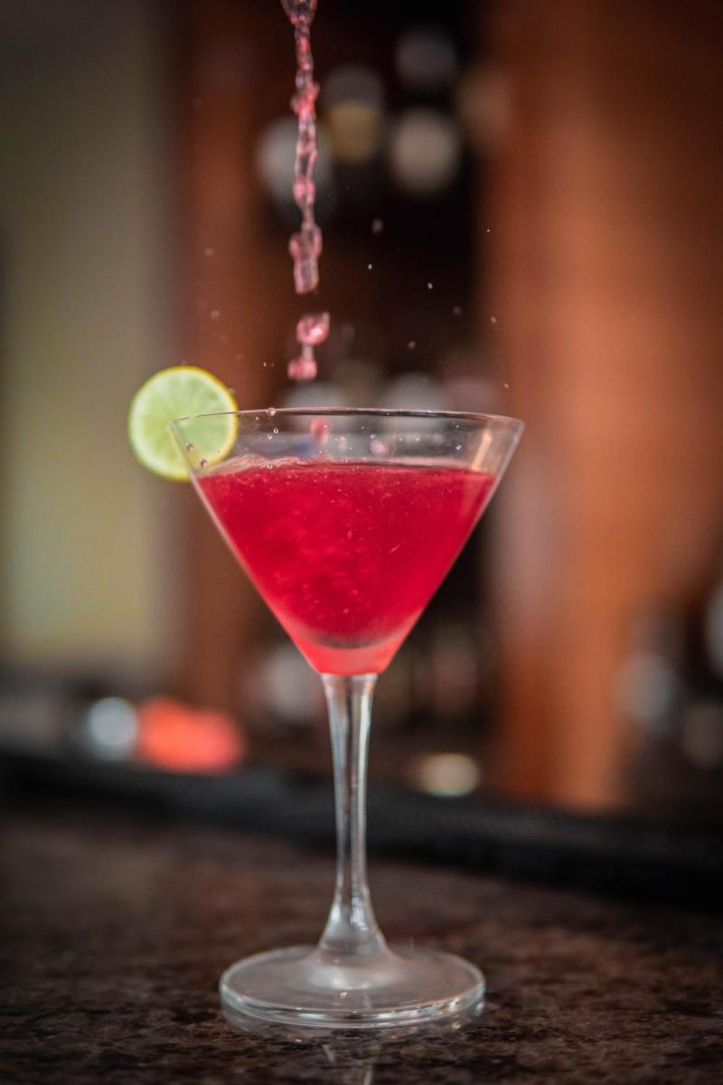 a red drink in a martini glass with a lime at Hyatt Place Pune Hinjawadi in Pune