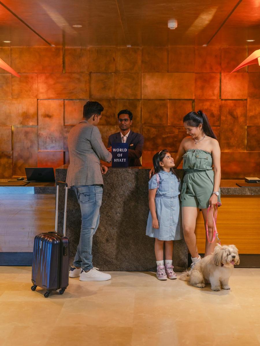 a group of people standing around a bar with a dog at Hyatt Place Pune Hinjawadi in Pune