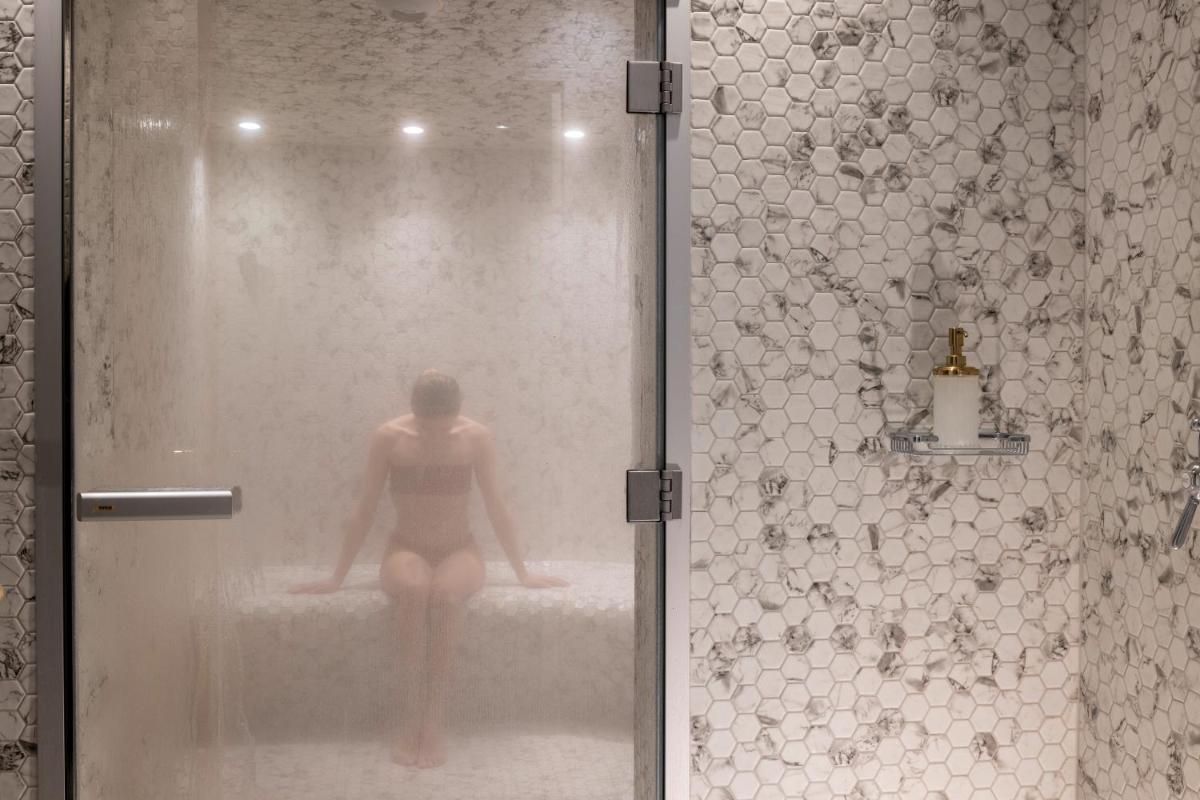 une femme dans une baignoire sous une douche dans l'établissement Le Belmont Paris, à Paris 42 autres photos