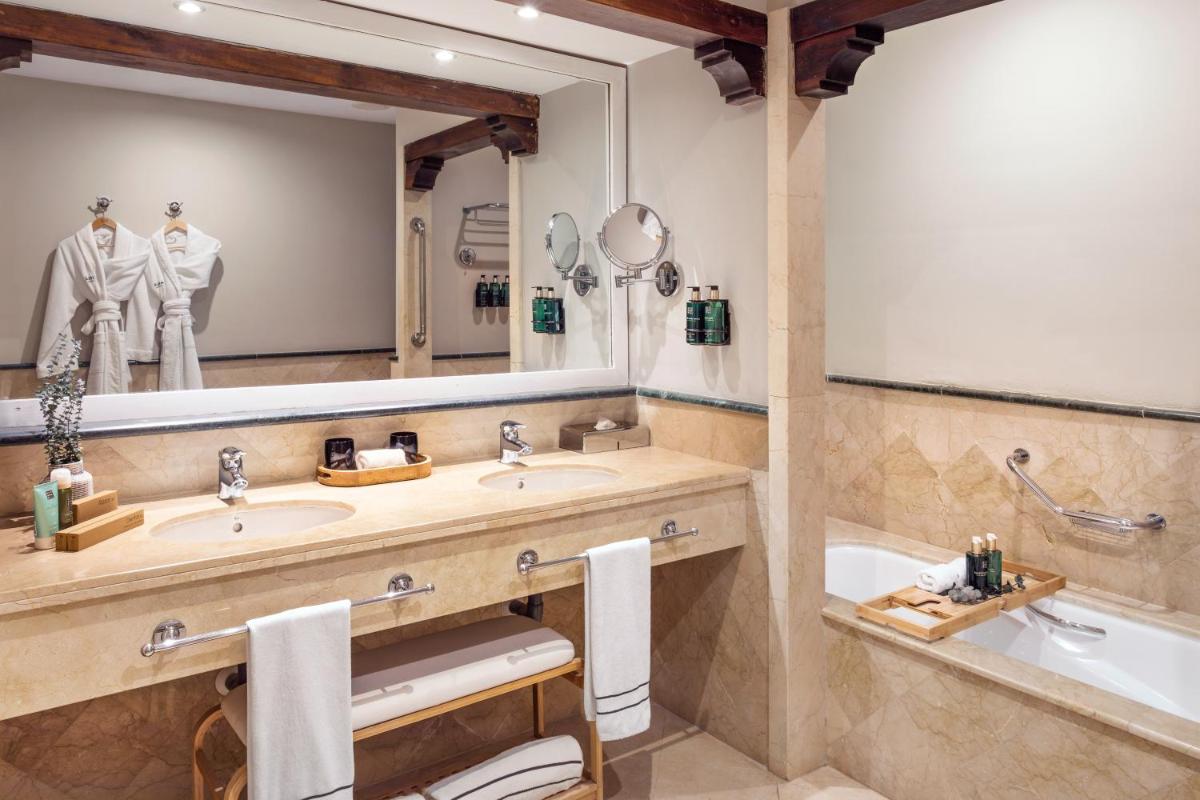 Un baño con dos lavabos y un espejo grande. en The Level at Meliá Villaitana, en Benidorm