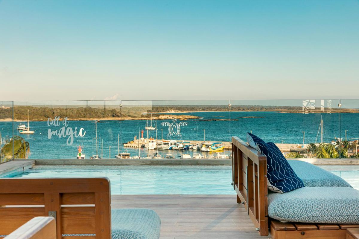 balcón con piscina y vistas al puerto deportivo en Hotel Honucai, en Colonia de Sant Jordi