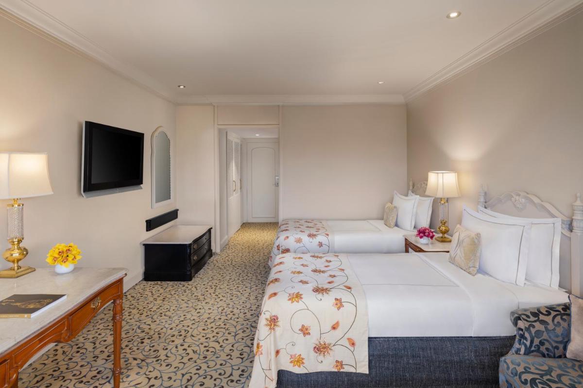 a hotel room with two beds and a desk at Taj Palace, New Delhi in New Delhi a hotel room with two beds and a desk at Taj Palace, New Delhi in New Delhi