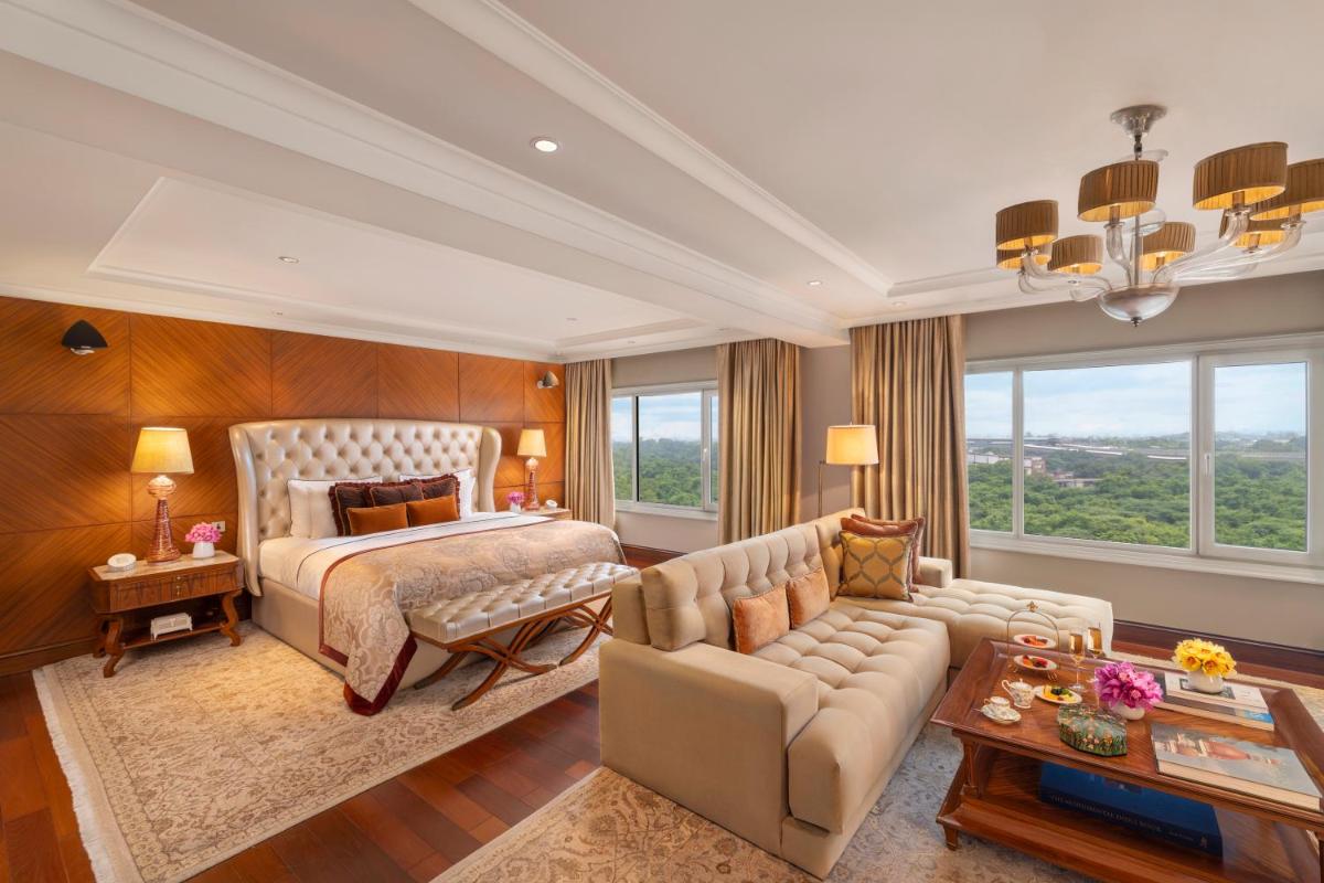 a bedroom with a bed and a living room with a couch at Taj Palace, New Delhi in New Delhi a bedroom with a bed and a living room with a couch at Taj Palace, New Delhi in New Delhi