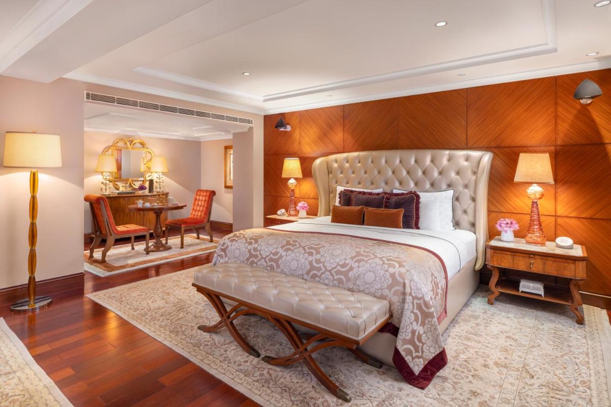 a bedroom with a large bed and a desk at Taj Palace, New Delhi in New Delhi a bedroom with a large bed and a desk at Taj Palace, New Delhi in New Delhi