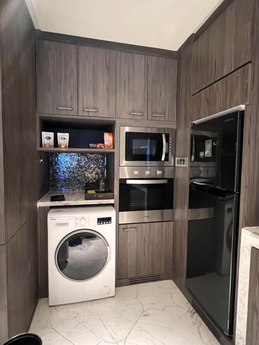 a kitchen with a washing machine and a microwave at ITC Kohenur, a Luxury Collection Hotel, Hyderabad in Hyderabad
