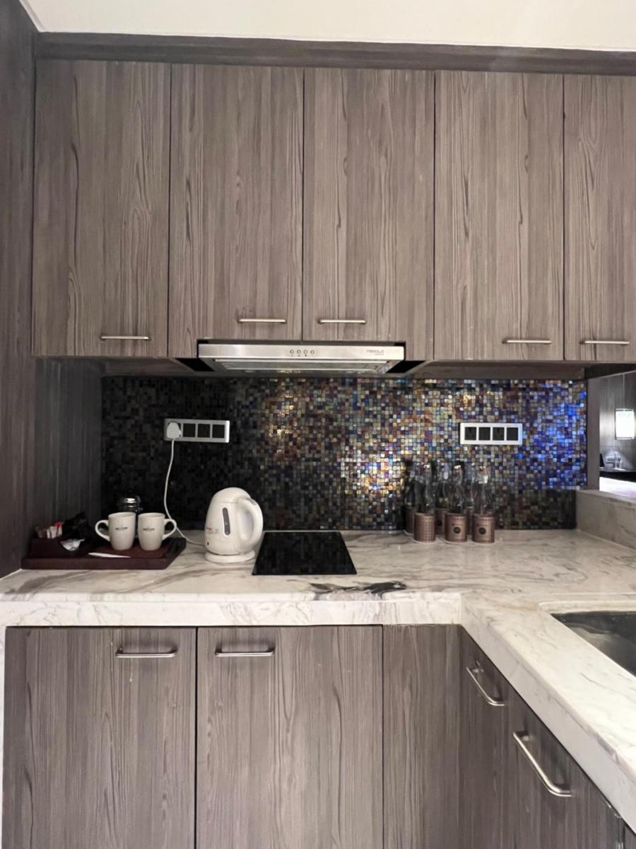 a kitchen with wooden cabinets and a counter top at ITC Kohenur, a Luxury Collection Hotel, Hyderabad in Hyderabad