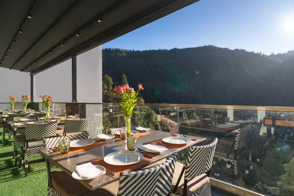 a table with vases of flowers on top of a balcony at Welcomhotel by ITC Hotels, Shimla in Shimla