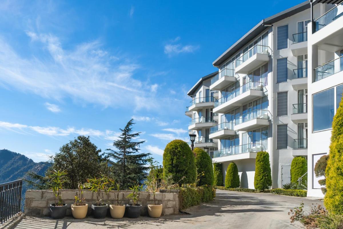 an apartment building with a driveway and plants at Welcomhotel by ITC Hotels, Shimla in Shimla